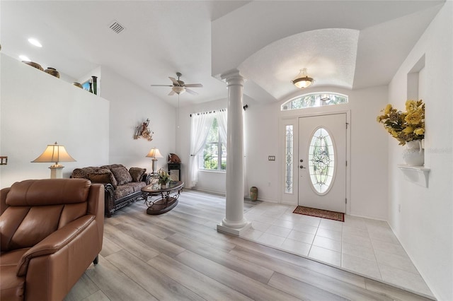 foyer featuring ceiling fan, decorative columns, light hardwood / wood-style floors, and a healthy amount of sunlight