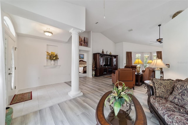 living room featuring light wood-type flooring, vaulted ceiling, ceiling fan, and ornate columns