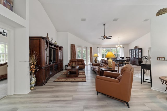 living room with ceiling fan with notable chandelier, light wood-type flooring, and high vaulted ceiling