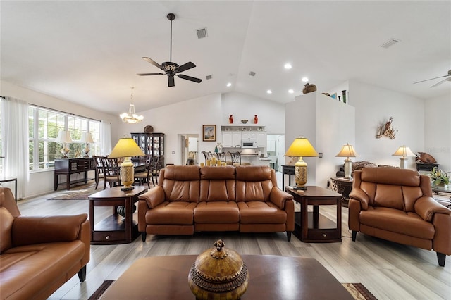 living room with ceiling fan with notable chandelier, light wood-type flooring, and lofted ceiling