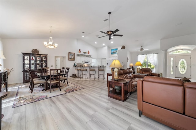 living room featuring light wood-type flooring, ceiling fan with notable chandelier, and high vaulted ceiling