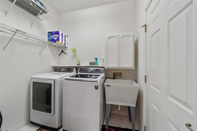 laundry room featuring cabinets and washer and clothes dryer