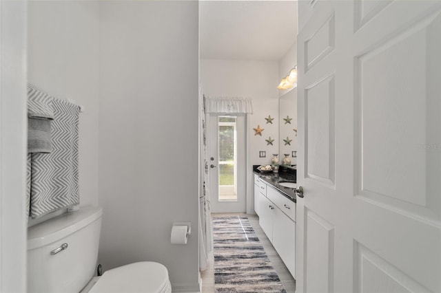 bathroom featuring hardwood / wood-style floors, vanity, and toilet