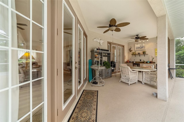 sunroom / solarium featuring ceiling fan and french doors