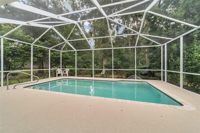 view of swimming pool with glass enclosure and a patio