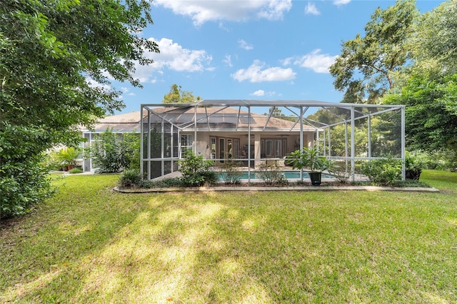 rear view of house with glass enclosure and a yard