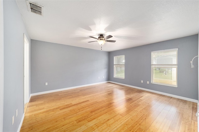 unfurnished room with ceiling fan, light hardwood / wood-style flooring, and a textured ceiling