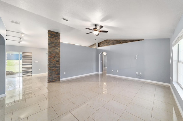 spare room with ceiling fan, ornate columns, light tile patterned floors, and vaulted ceiling