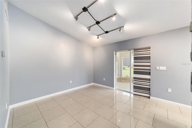 unfurnished room with rail lighting and light tile patterned flooring