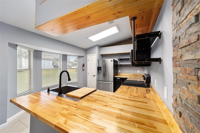 kitchen featuring wooden counters, appliances with stainless steel finishes, kitchen peninsula, sink, and lofted ceiling