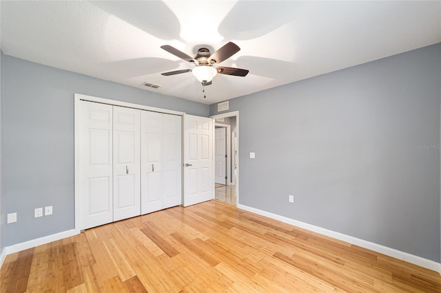 unfurnished bedroom featuring a closet, light hardwood / wood-style floors, and ceiling fan