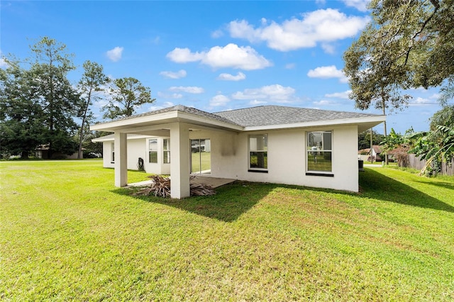 rear view of property with a lawn and a patio area