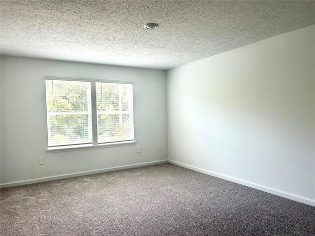 carpeted spare room featuring a textured ceiling