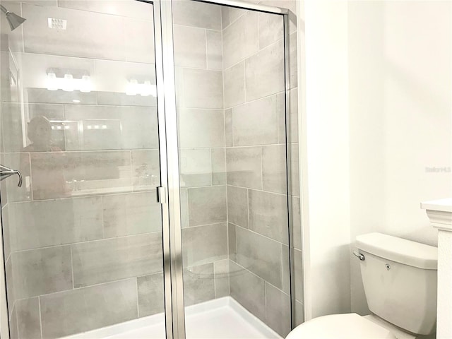 bathroom with toilet and a shower with shower door