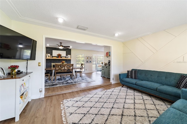 living room featuring a textured ceiling, hardwood / wood-style flooring, and ceiling fan