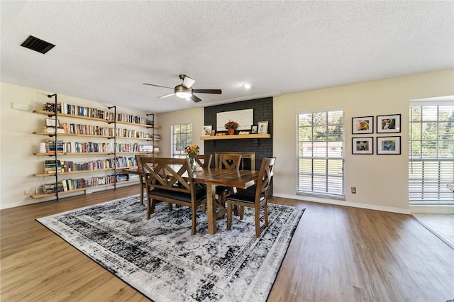 dining room with a wealth of natural light, a textured ceiling, and hardwood / wood-style flooring