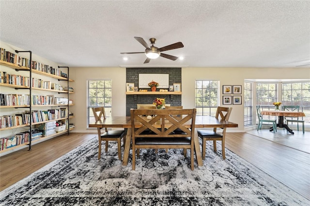 dining area featuring a wealth of natural light, a textured ceiling, hardwood / wood-style flooring, and ceiling fan