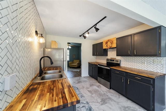 kitchen featuring light hardwood / wood-style floors, wooden counters, stainless steel appliances, and sink