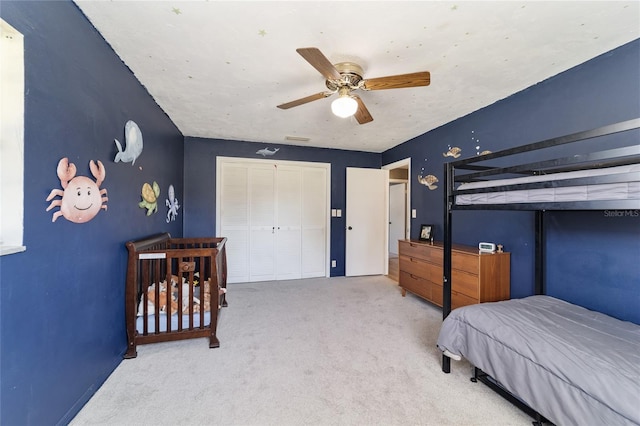 carpeted bedroom featuring a closet and ceiling fan