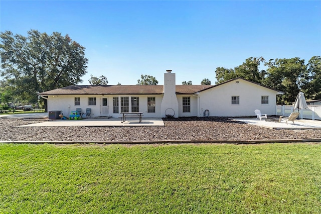 rear view of property featuring a patio and a yard