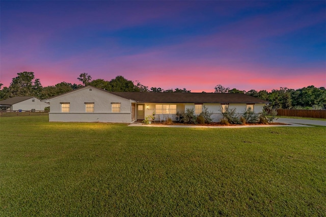 ranch-style home featuring a lawn