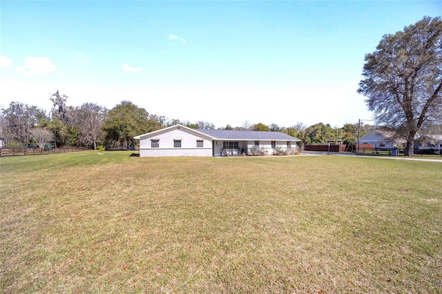 ranch-style home featuring a front yard and fence