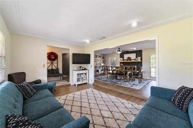 living room with a textured ceiling, ceiling fan, dark wood-style flooring, and visible vents