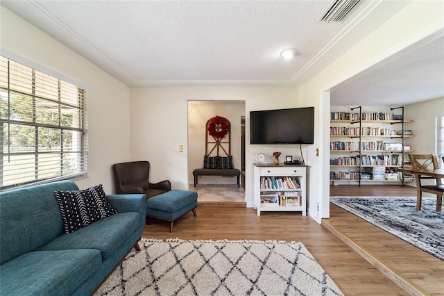 living area featuring a textured ceiling, visible vents, and wood finished floors