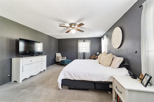 bedroom featuring a textured ceiling, visible vents, a ceiling fan, and light colored carpet