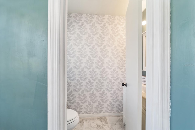 bathroom featuring marble finish floor, baseboards, vanity, and toilet