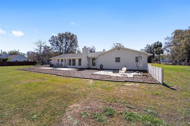 back of property with a yard, a patio area, and fence