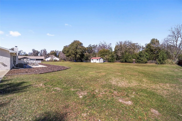 view of yard with a shed, fence, and an outdoor structure