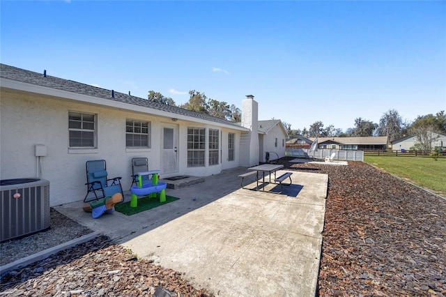 back of house featuring a chimney, fence, a patio area, central AC, and stucco siding