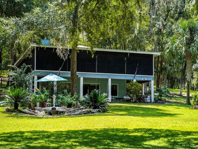 back of house featuring a yard and a sunroom