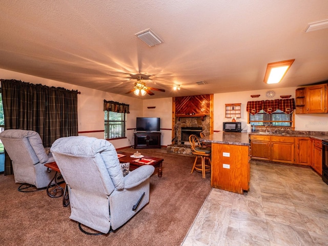 living room with a textured ceiling, a fireplace, and ceiling fan