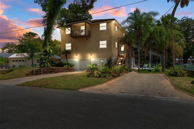 view of front of property with a yard, a balcony, and a garage