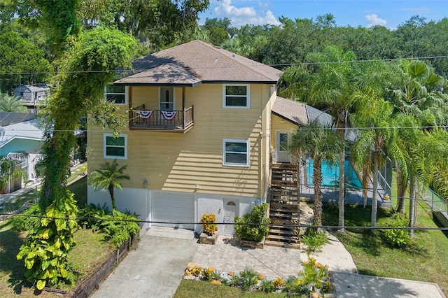 view of front of home featuring a balcony and a garage