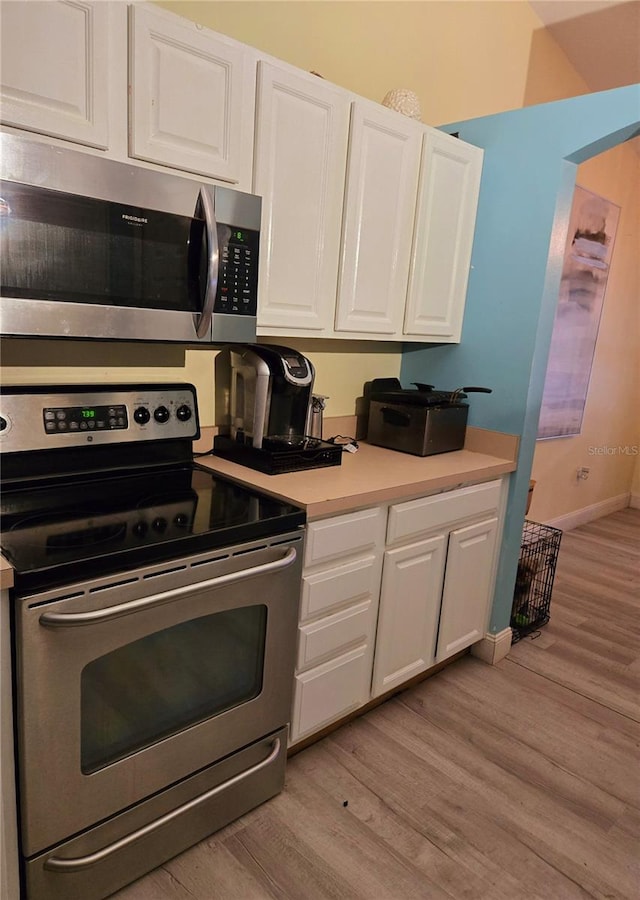 kitchen featuring appliances with stainless steel finishes, light hardwood / wood-style floors, and white cabinetry