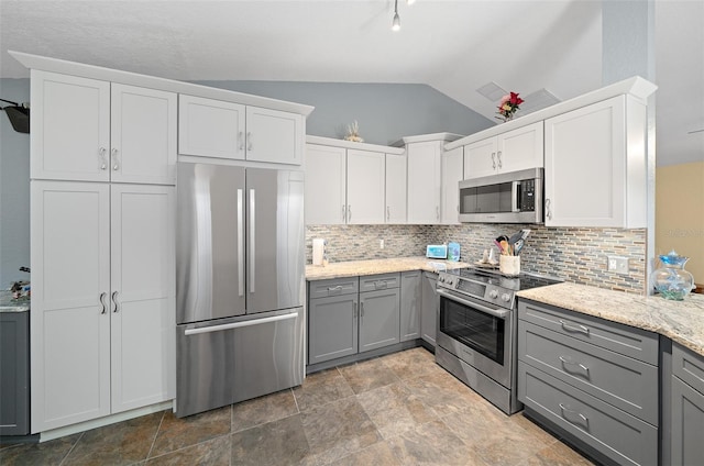 kitchen featuring gray cabinets, stainless steel appliances, vaulted ceiling, and white cabinets