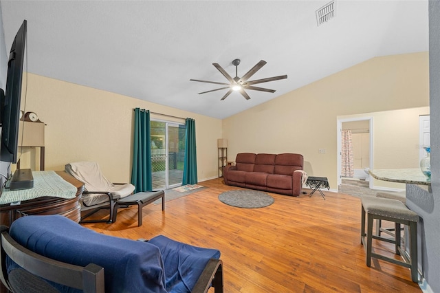 living room featuring ceiling fan, hardwood / wood-style flooring, and vaulted ceiling