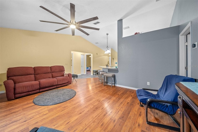 living room featuring lofted ceiling, light hardwood / wood-style floors, and ceiling fan