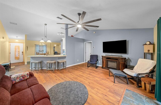 living room with vaulted ceiling, ceiling fan, light hardwood / wood-style flooring, and sink