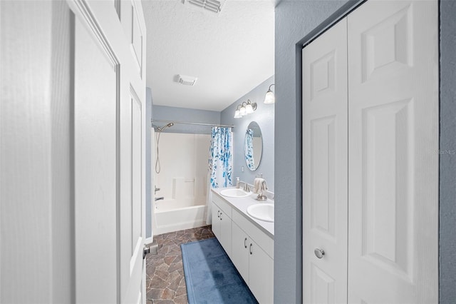 bathroom with shower / bath combination with curtain, vanity, and a textured ceiling