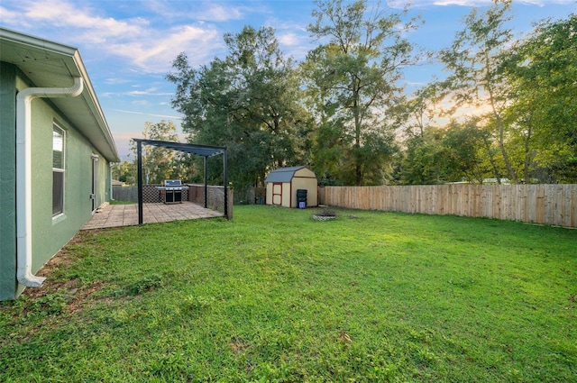 yard at dusk featuring a patio and a shed