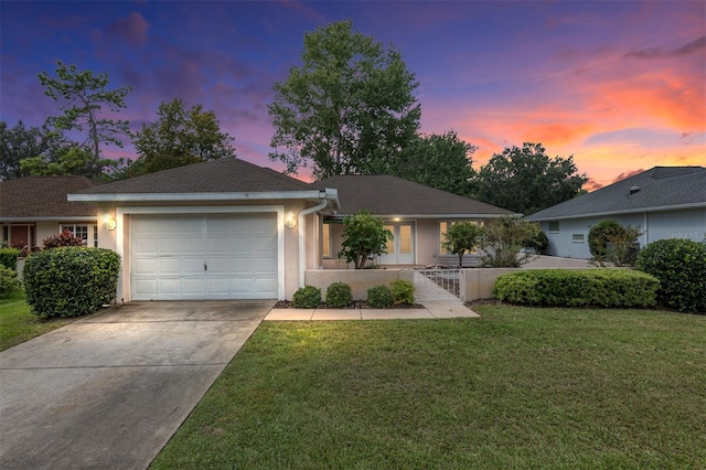 ranch-style house featuring a lawn and a garage