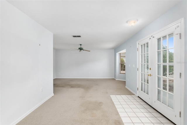 spare room featuring ceiling fan, french doors, light colored carpet, and a healthy amount of sunlight