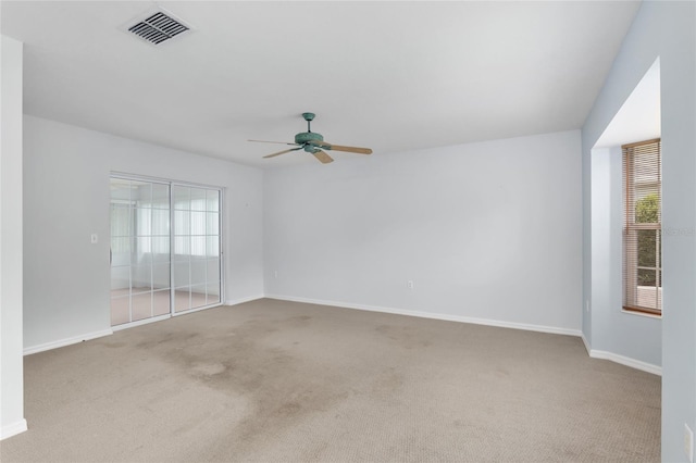 carpeted empty room featuring ceiling fan and plenty of natural light