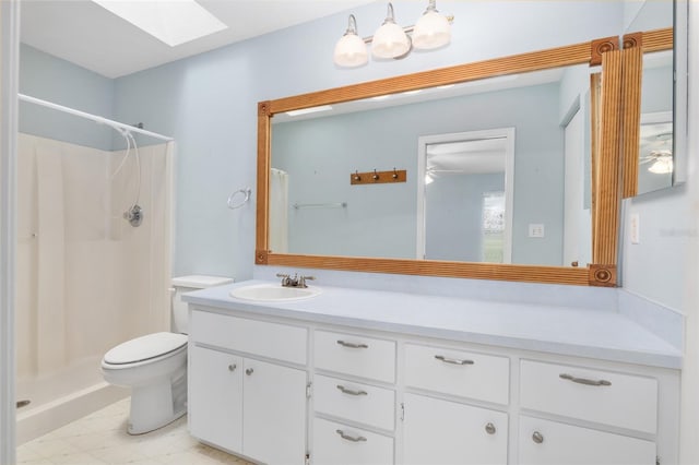 bathroom featuring walk in shower, a skylight, vanity, and toilet