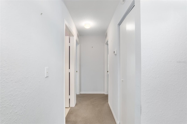 hall with light colored carpet