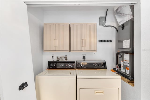 washroom with washing machine and clothes dryer and cabinets